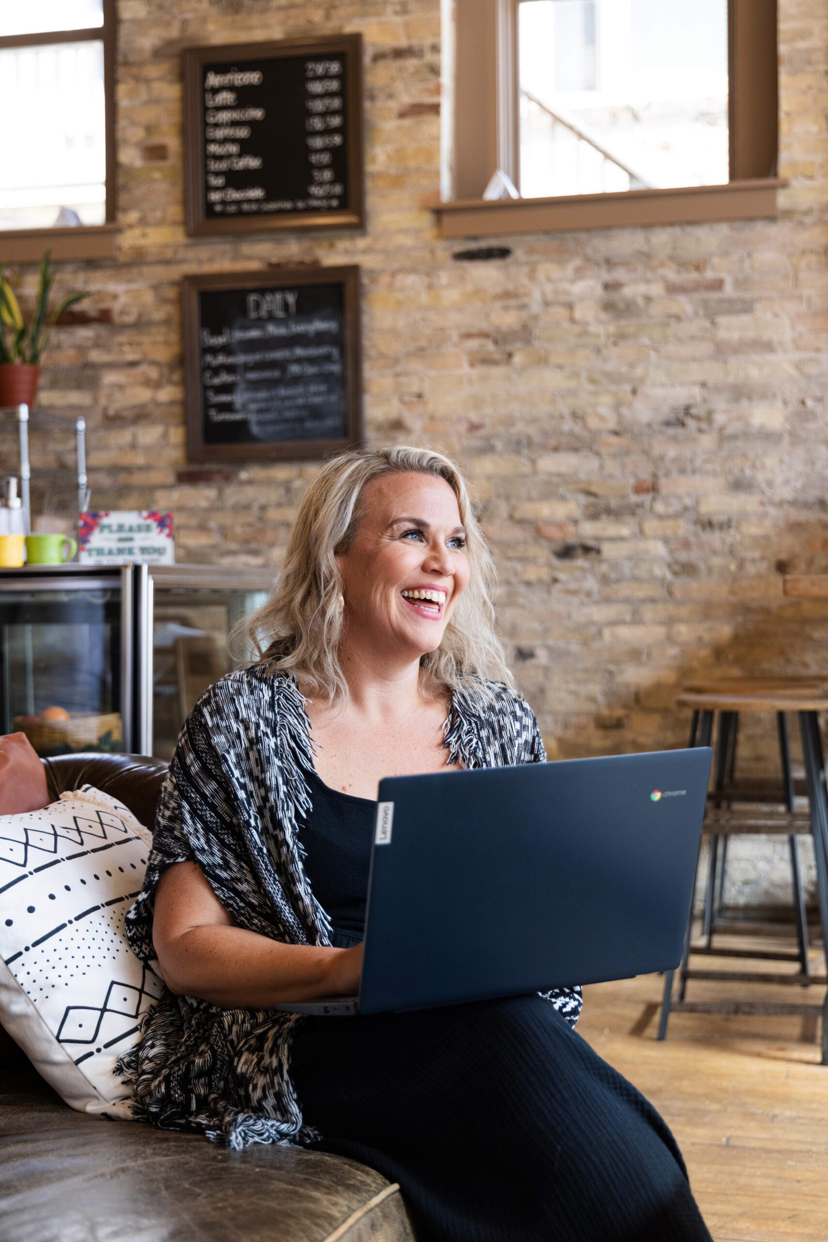 Stephanie Steinert sitting on coach with laptop Travel With Class