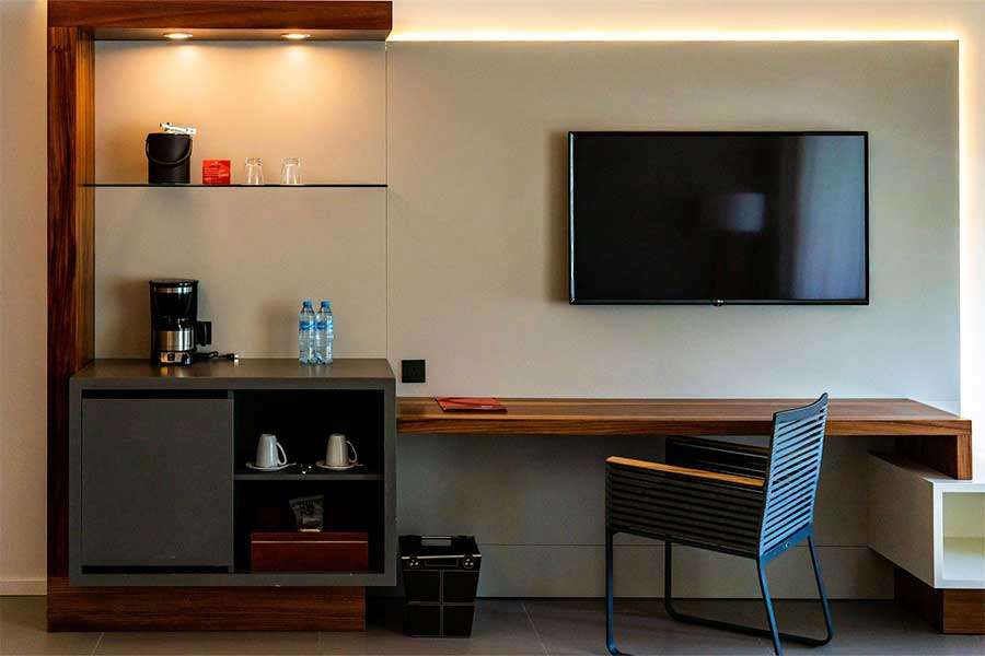 Modern hotel room workspace with coffee station.