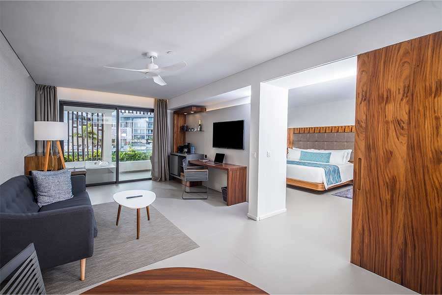 Modern hotel room with living area and bedroom.