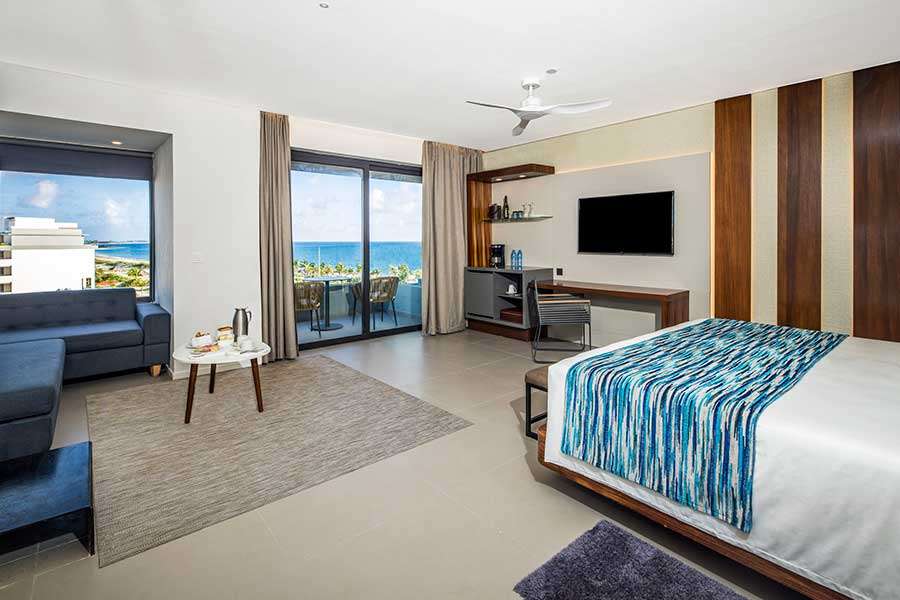 Modern hotel room with ocean view and amenities.