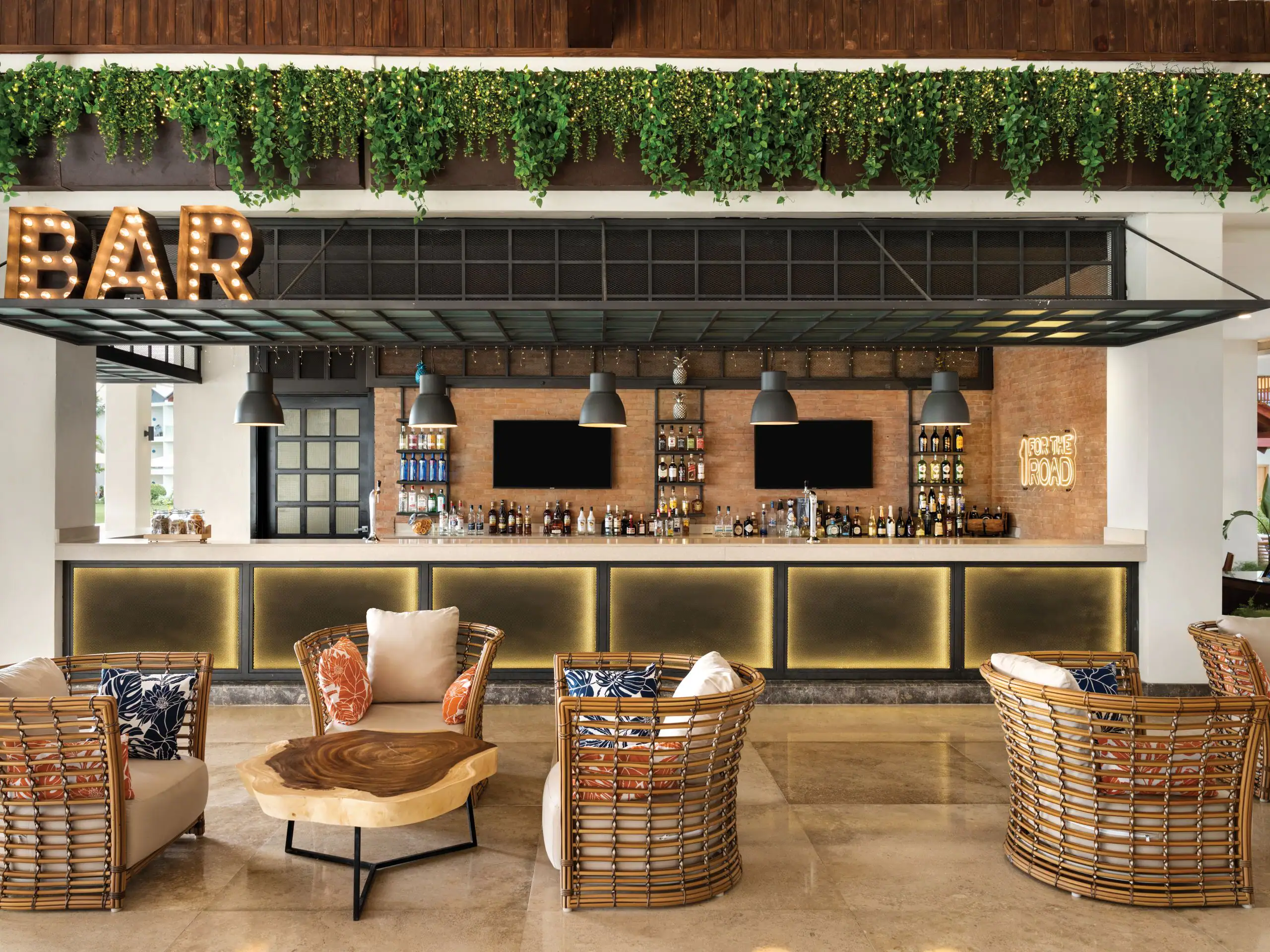 Dreams La Romana 2 Cozy bar with wicker chairs and plant decor.