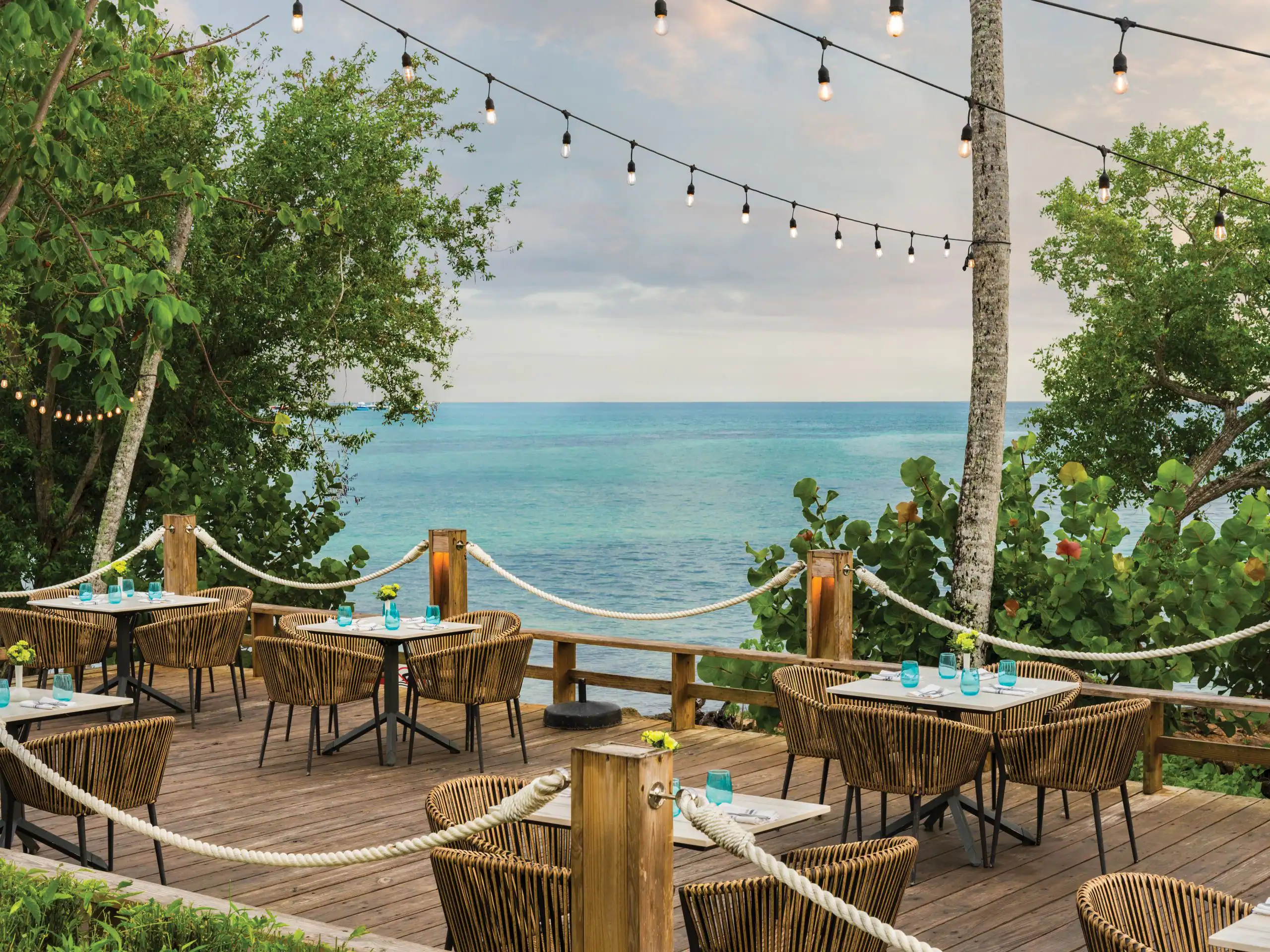 Dreams La Romana 8 Scenic outdoor restaurant with ocean view and string lights.