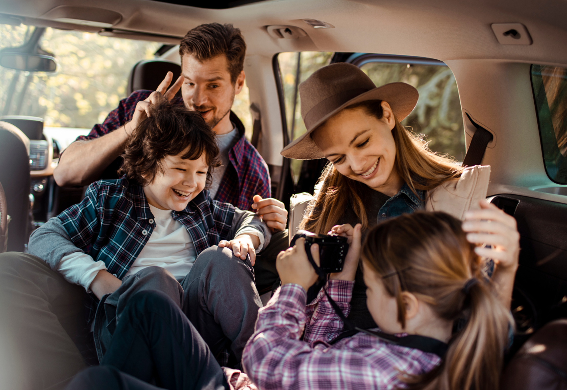 Family enjoys playful moment in car.