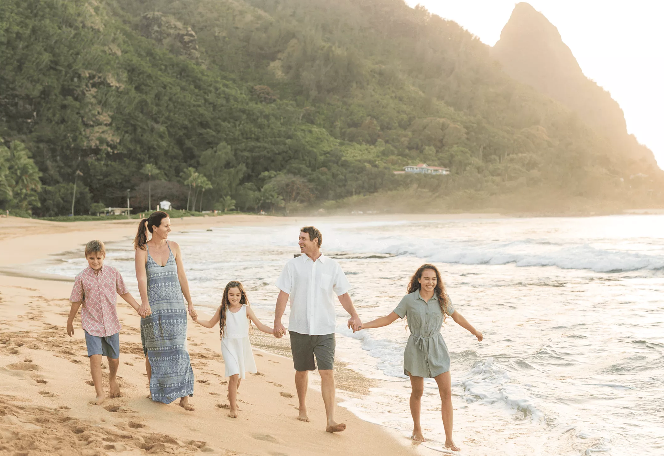 Family walking on a beach at sunset