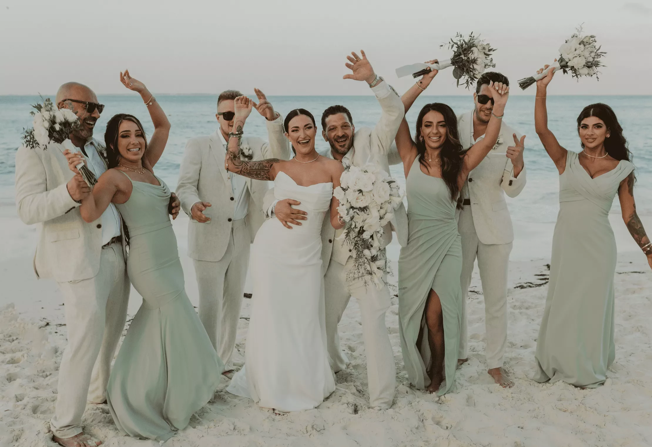 Joyful wedding party celebrating on the beach.