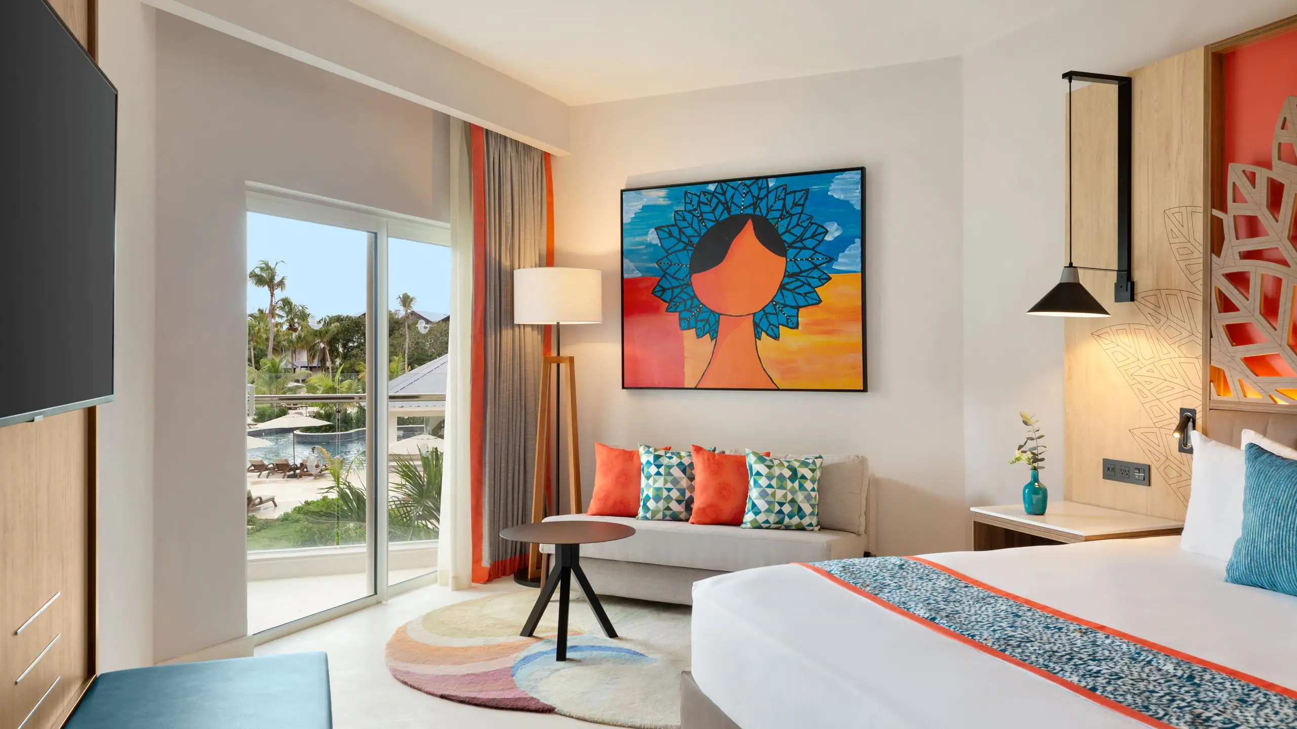 Modern hotel room with colorful decor and balcony view.