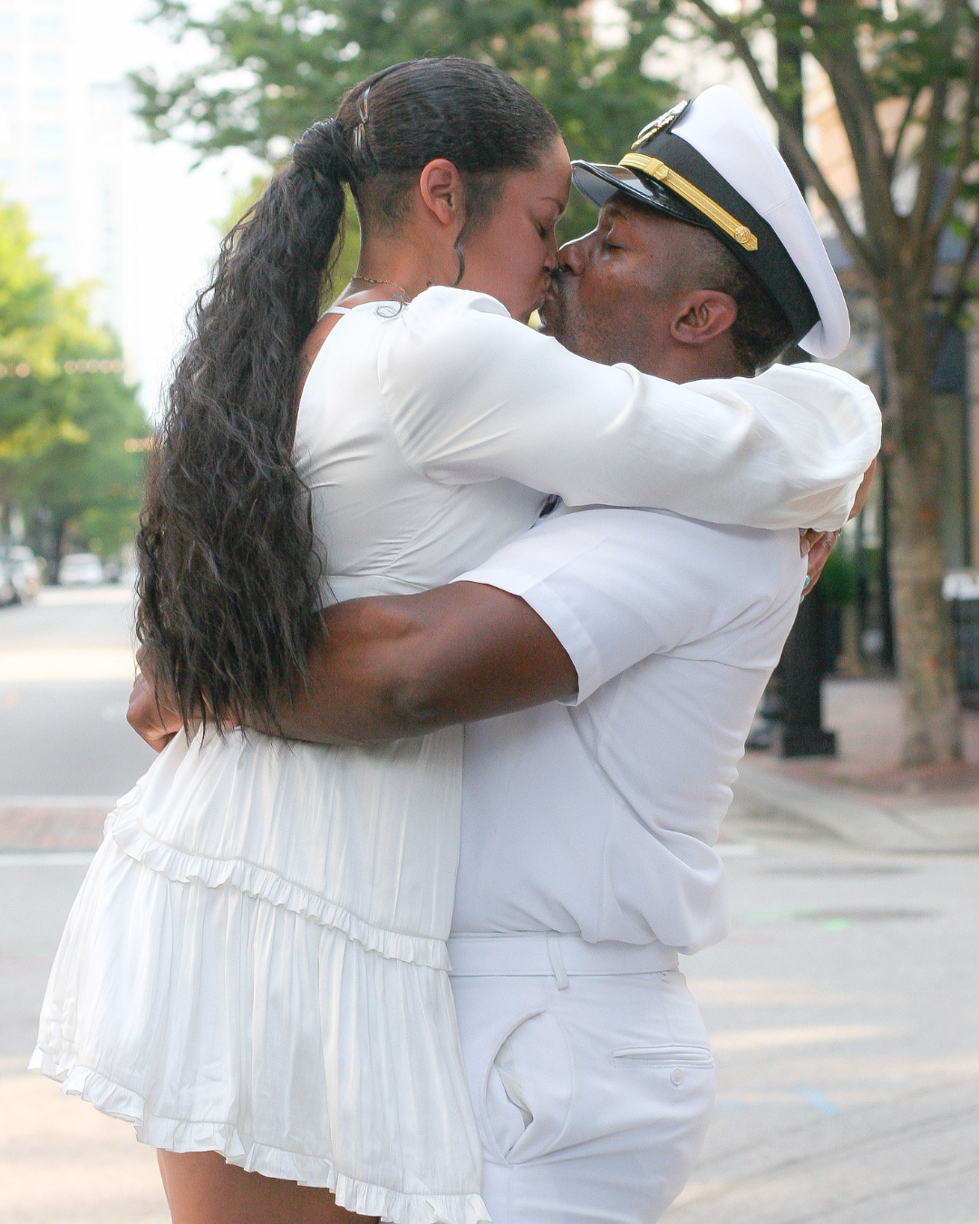 Sailor and woman kissing on city street