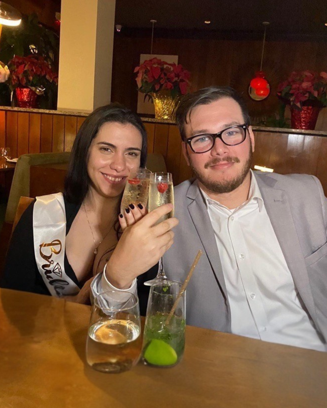 Couple celebrating with drinks at a restaurant.