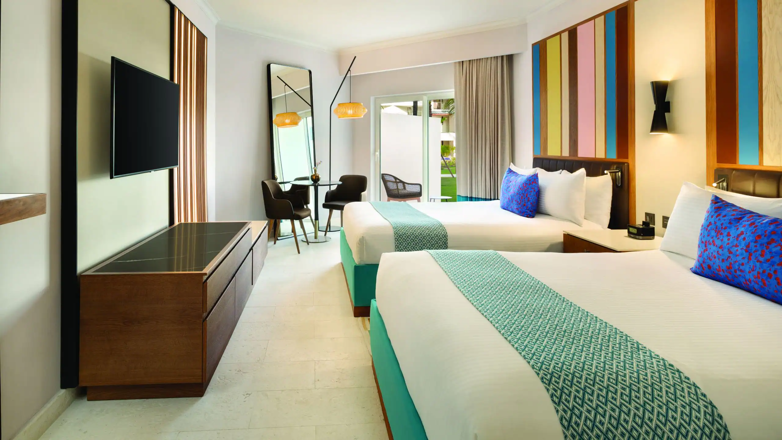 Modern hotel room with two beds, colorful decor.