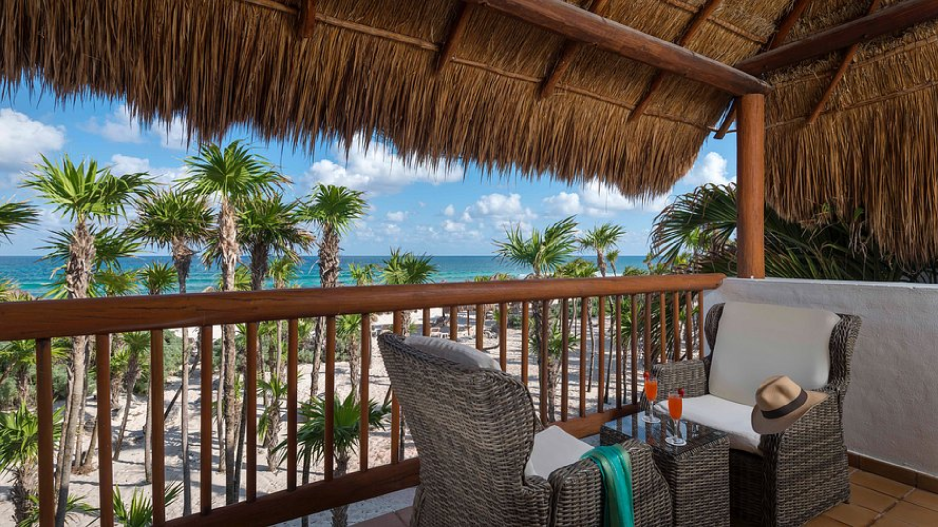 5 Tropical balcony view overlooking ocean and palm trees.