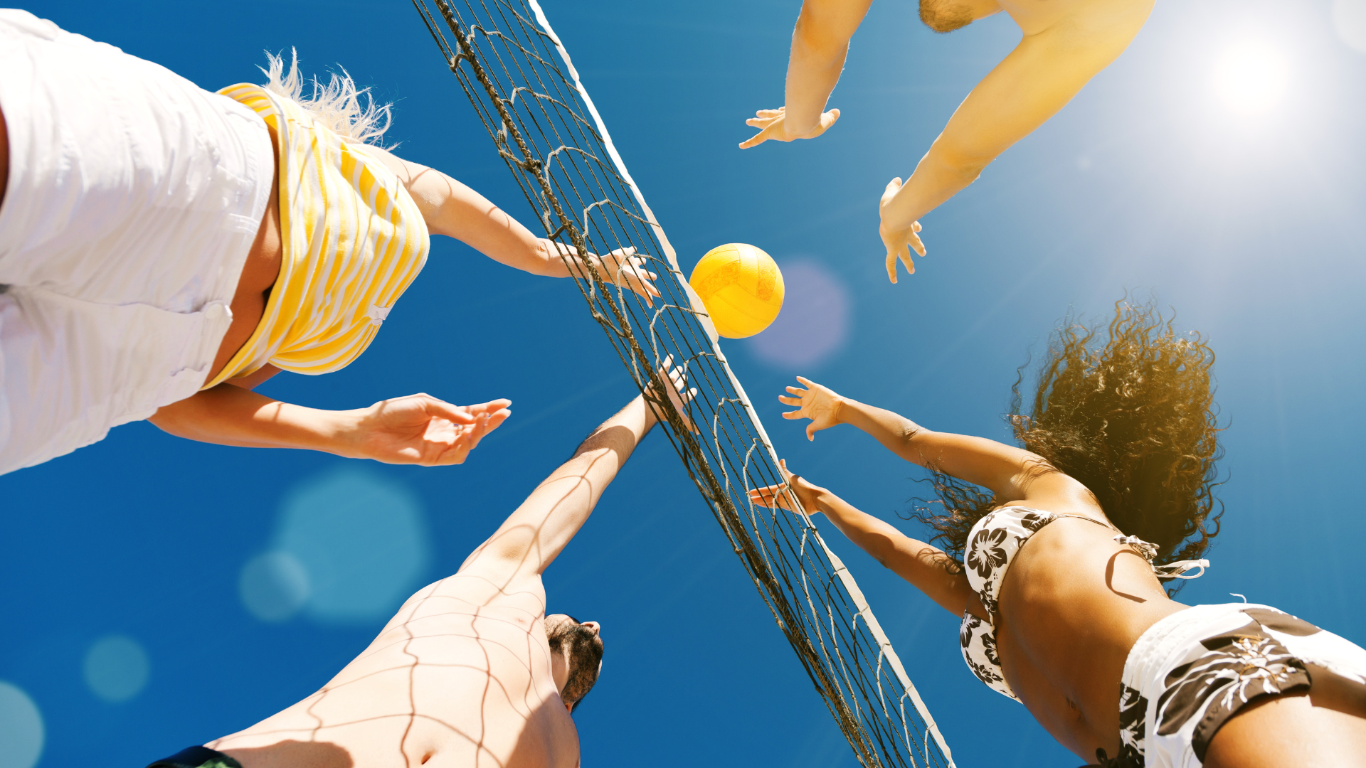 7 Beach volleyball game under sunny blue sky.