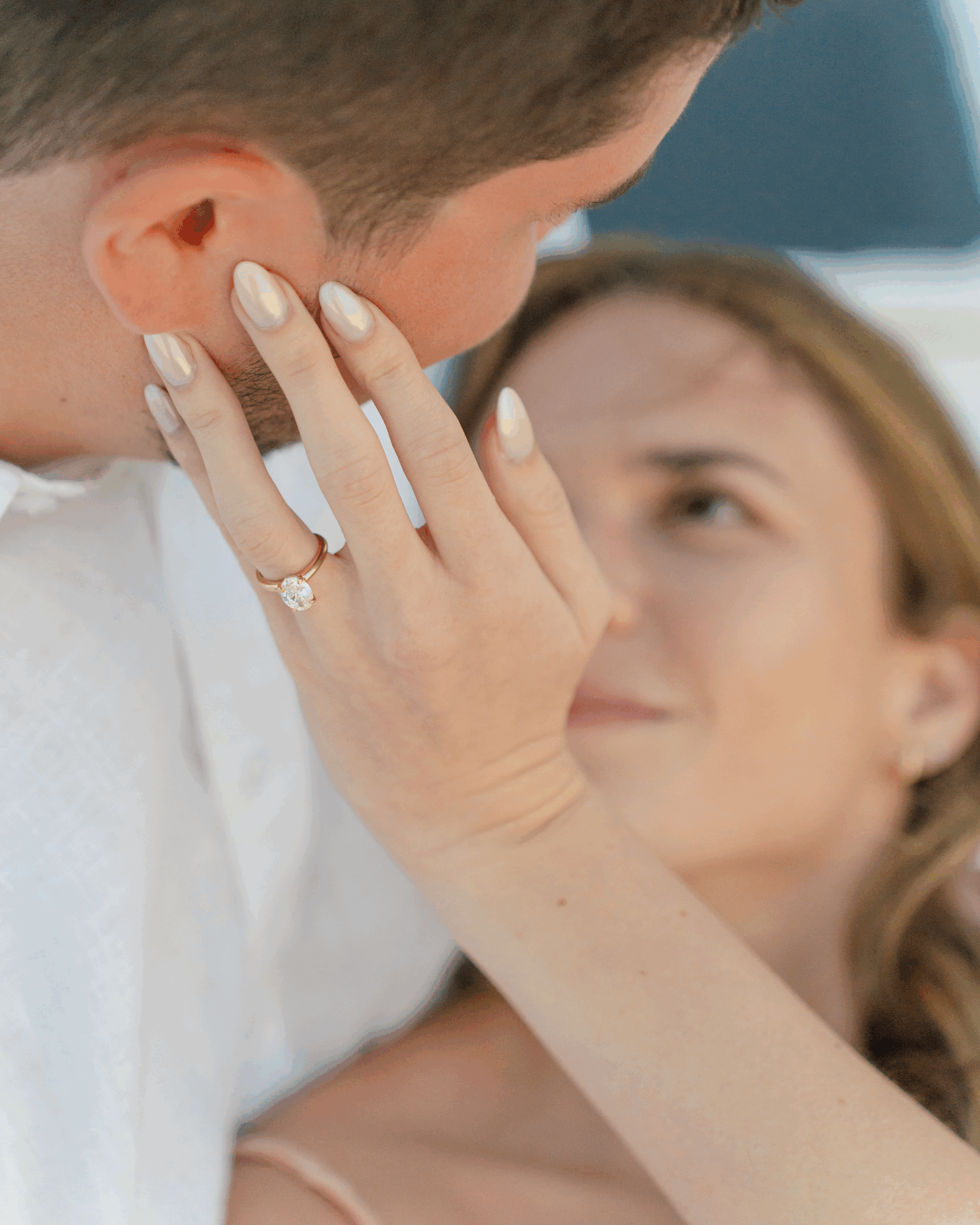Engagement ring close-up during intimate moment.