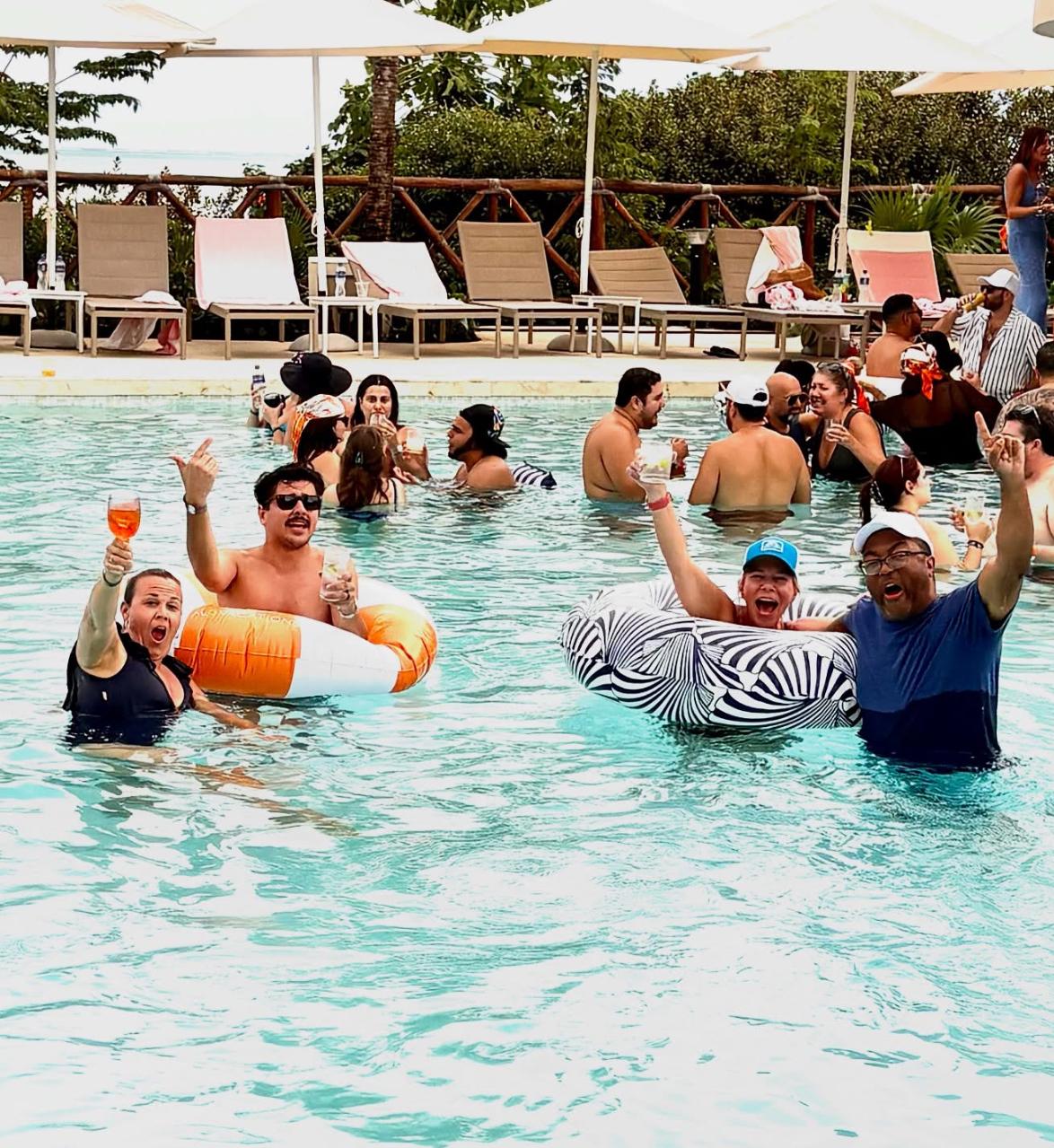 People enjoy a pool party with drinks.