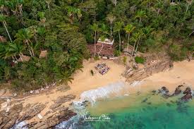 Aerial view of secluded tropical beach and lush forest.