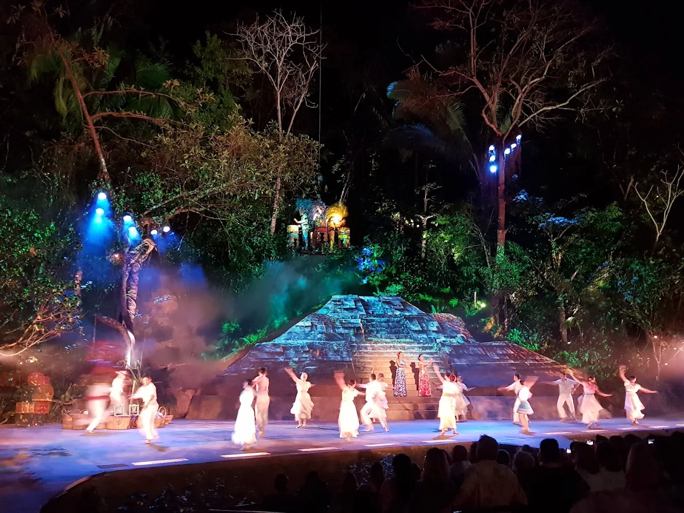Colorful night performance on ancient stage with dancers.