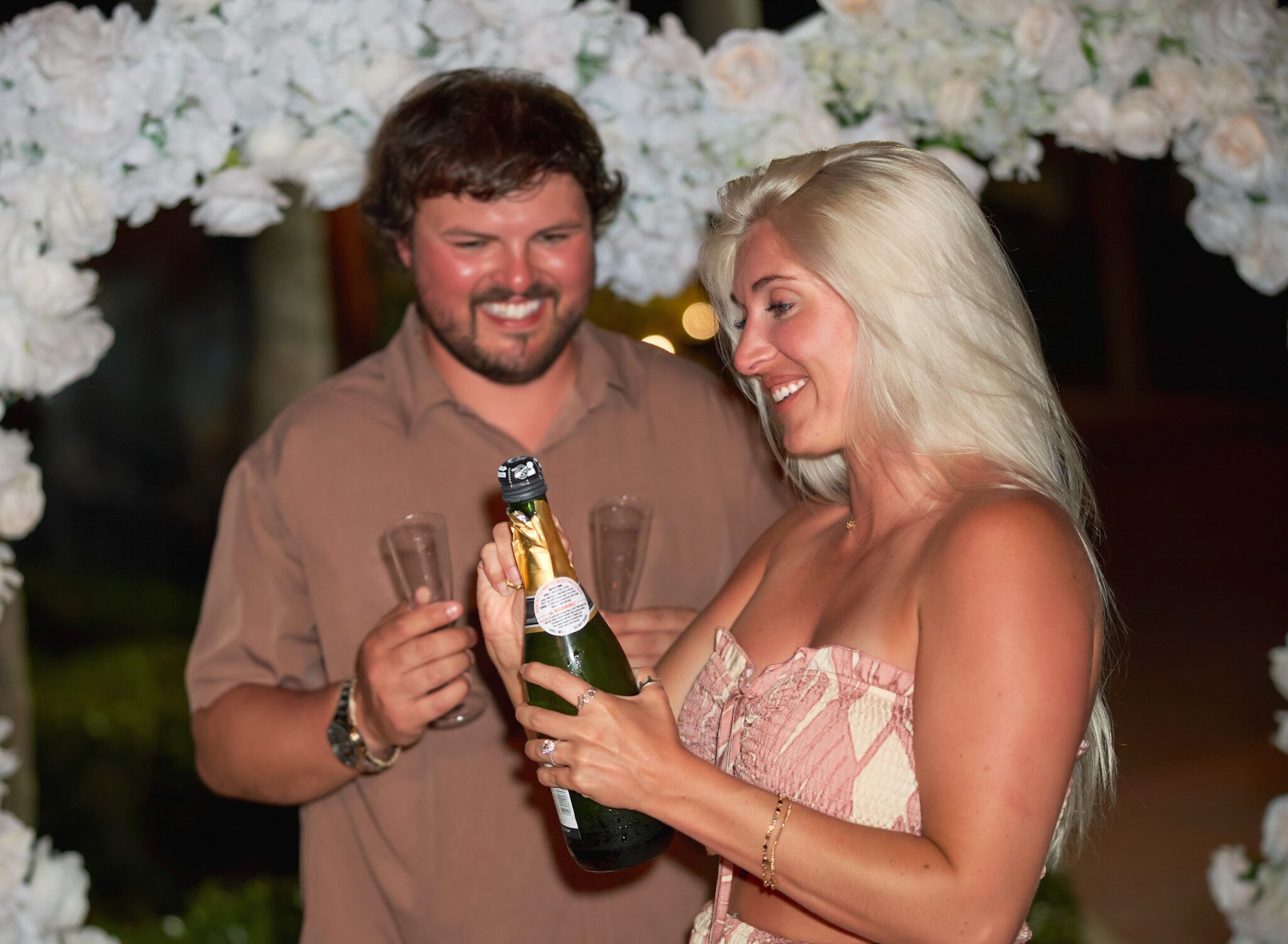 Couple celebrating with champagne and glasses.