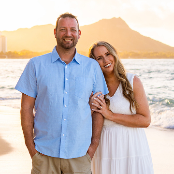 Couple smiling on beach with mountain background