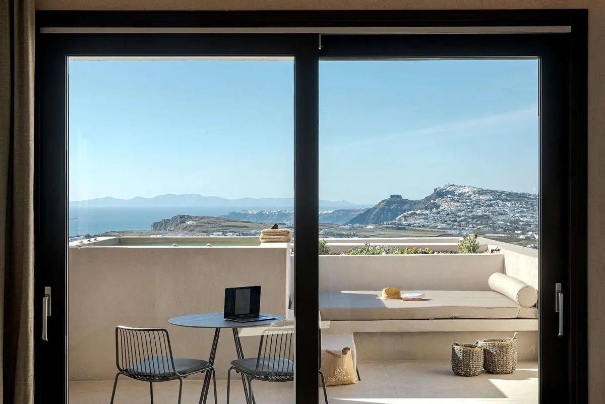 Suite terrace with daybed and table, looking across Santorini