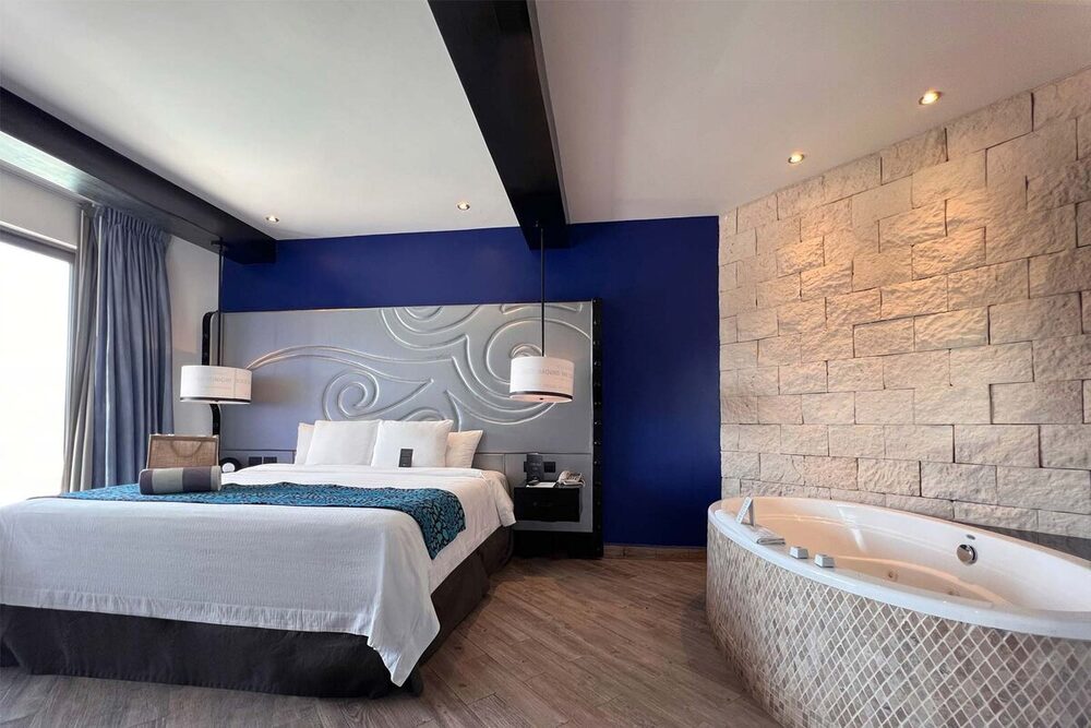 Rock Suite Ocean Front Rooftop Lounge, king bedroom with a stone feature wall and in-room jacuzzi, Heaven side