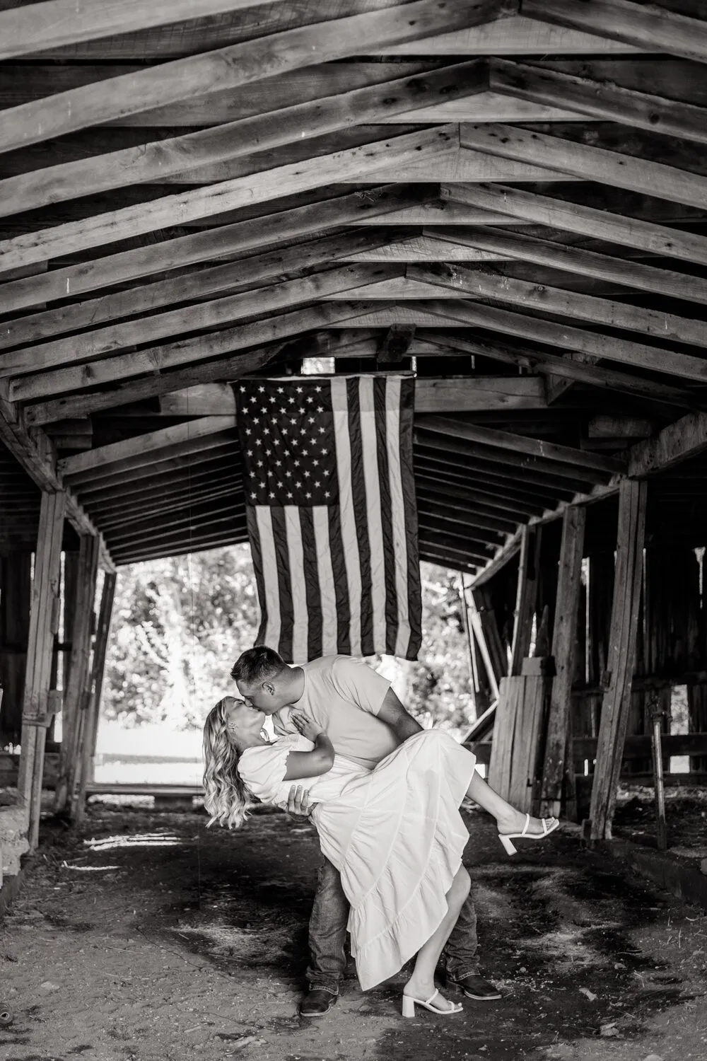 Nelius dipping Kassidy under a covered bridge, in black and white