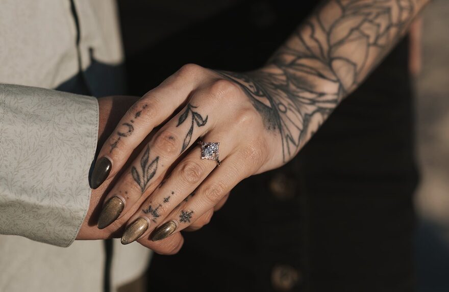 Sonya and Tyler holding hands, her engagement ring in view